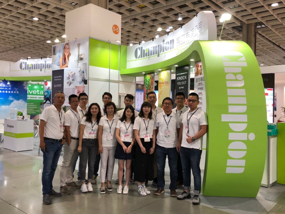 Group picture of employees in front of Champion exhibition stall