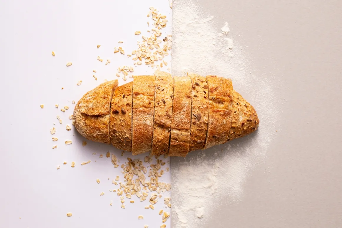 Sliced loaf of white bread on bright surface