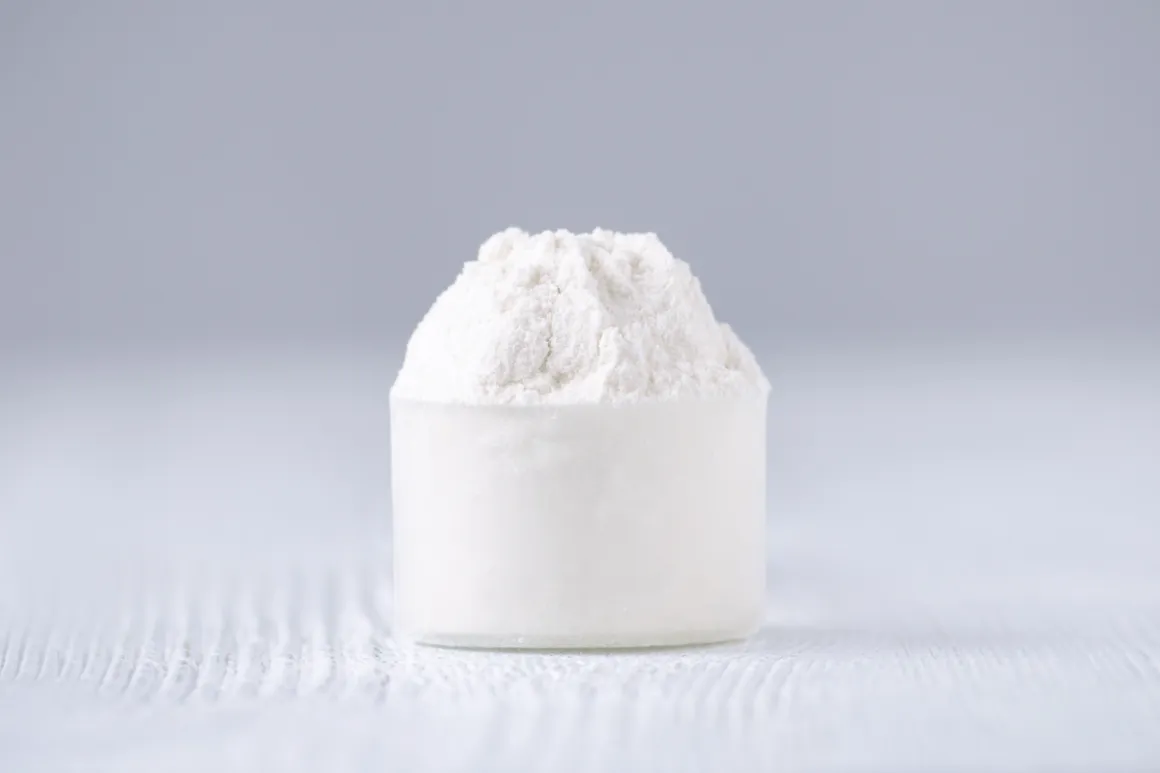 Transparent bowl with fine powder on white table