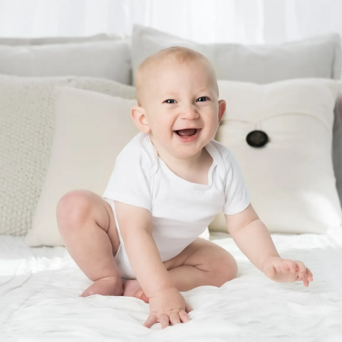  smiling baby sitting on a couch