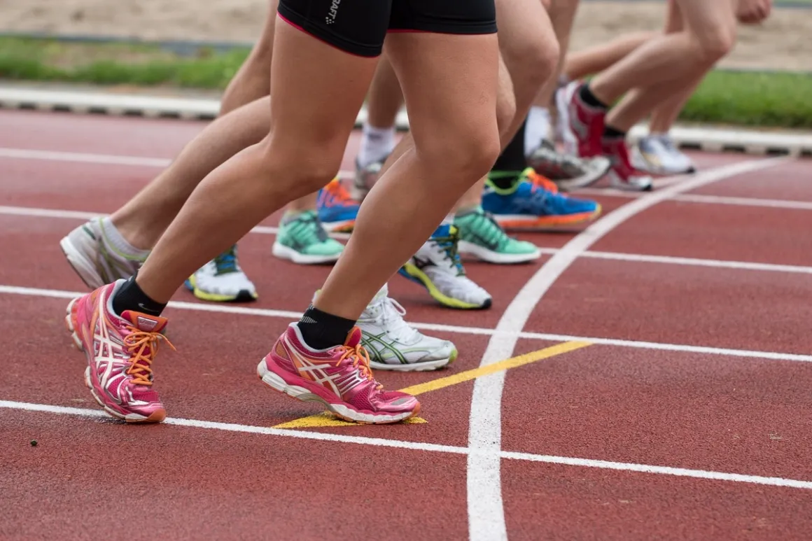 Multiple runner's legs and feet on a track