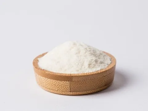 Flat wooden bowl with fine white powder