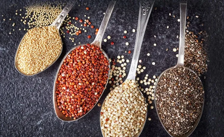 Metal spoons showing red, white and black quinoa