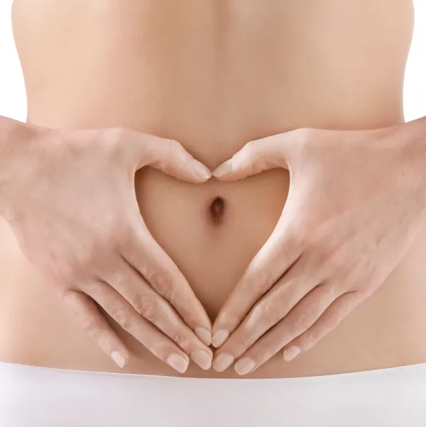 Woman forming the shape of a heart in front of her belly