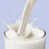milk being poured glossily into a glass