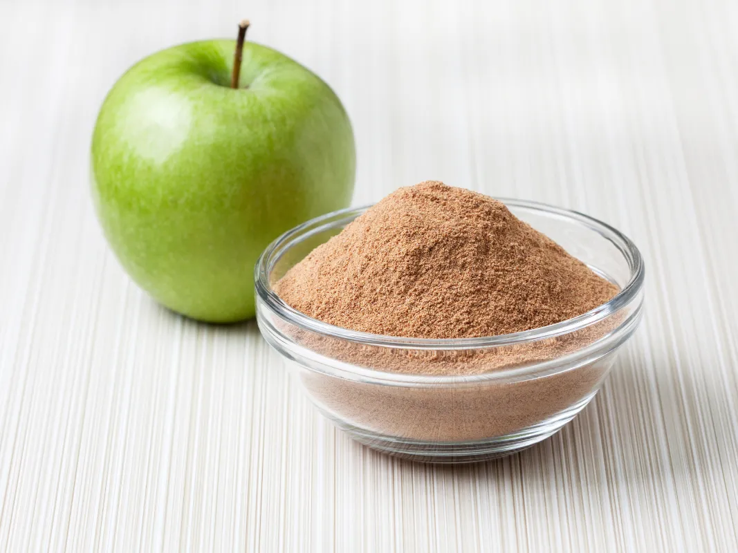 Green Apple and a transparent bowl with fine brown powder