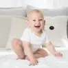 Smiling toddler sitting on a bed