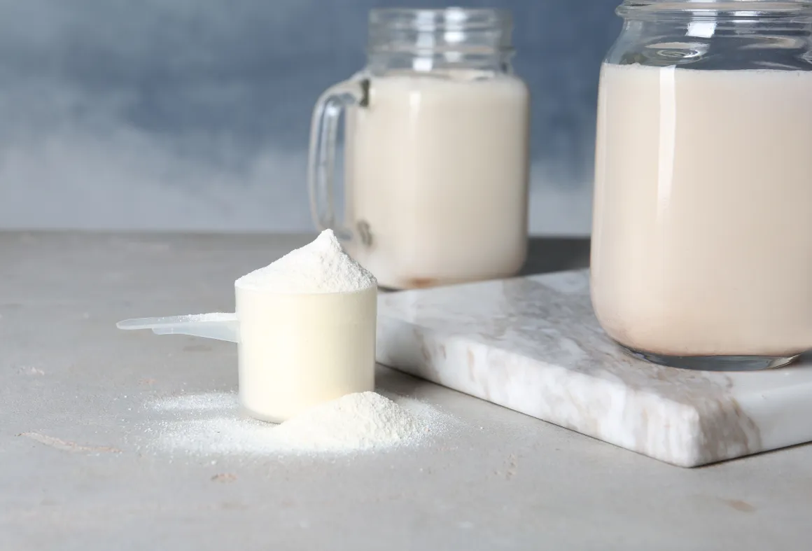 Jar with fine powder next to two glasses with milky liquid