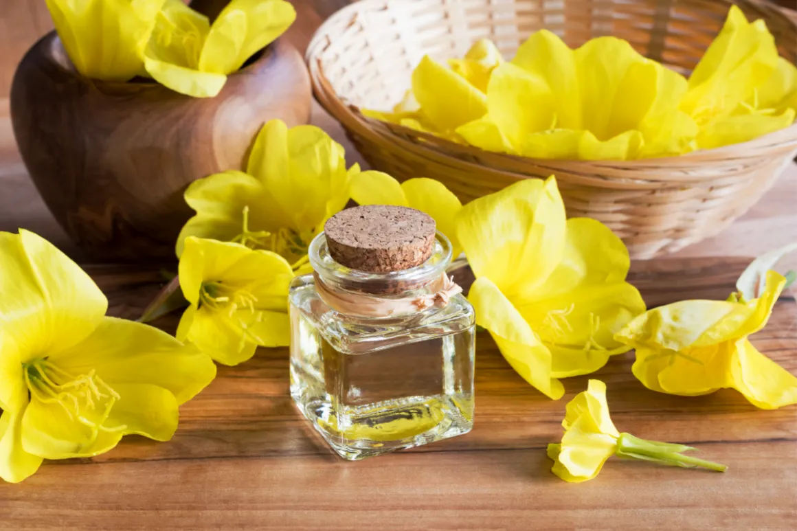 Vial with clear liquid on wooden table with wooden decorations and yellow flowers
