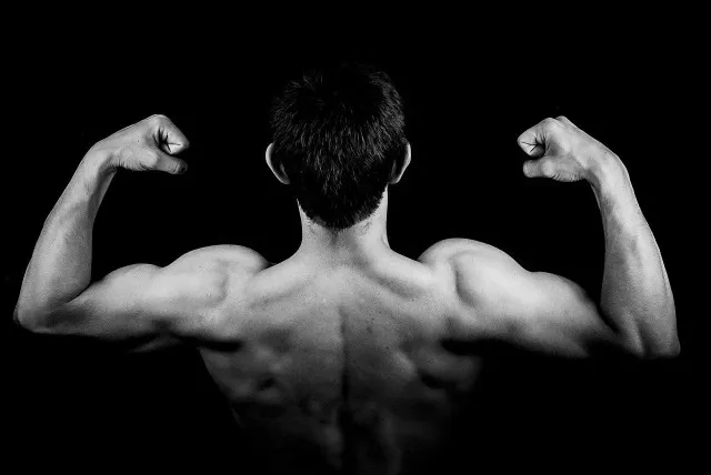 Black and white picture of an athletic man flexing his back muscle