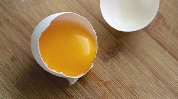 A cracked open egg showing the yolk