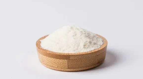 A wooden bowl filled with a fine white powder