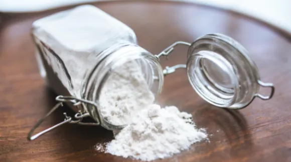 An opened jar filled with a white powder