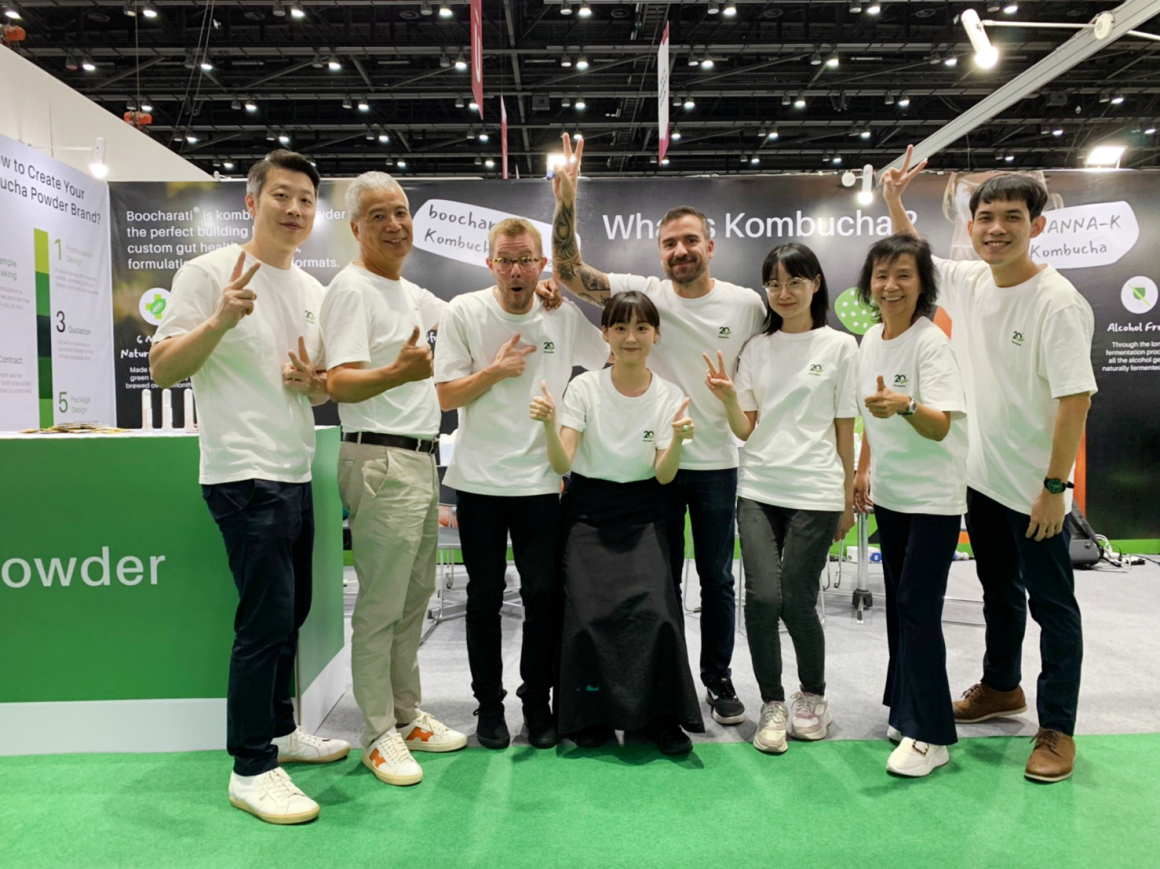 champion and mannanova employees standing together in front of the FIA booth