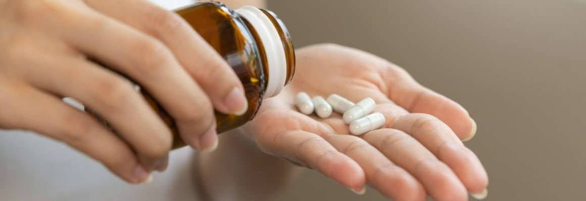 Image of a hand holding supplement capsules.