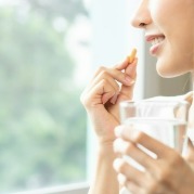 Image of a woman taking a supplement.