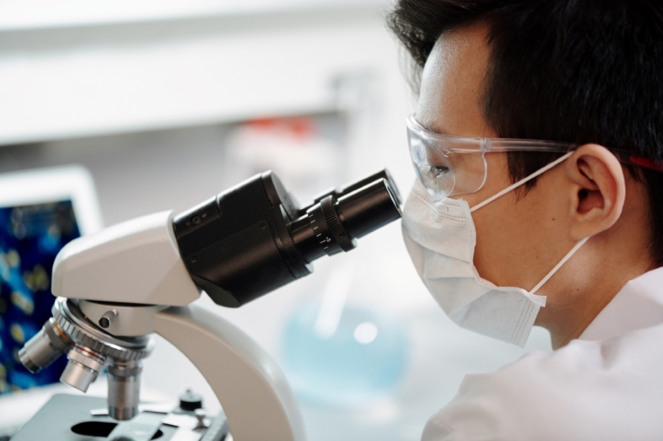 Male scientist looking through a microscope